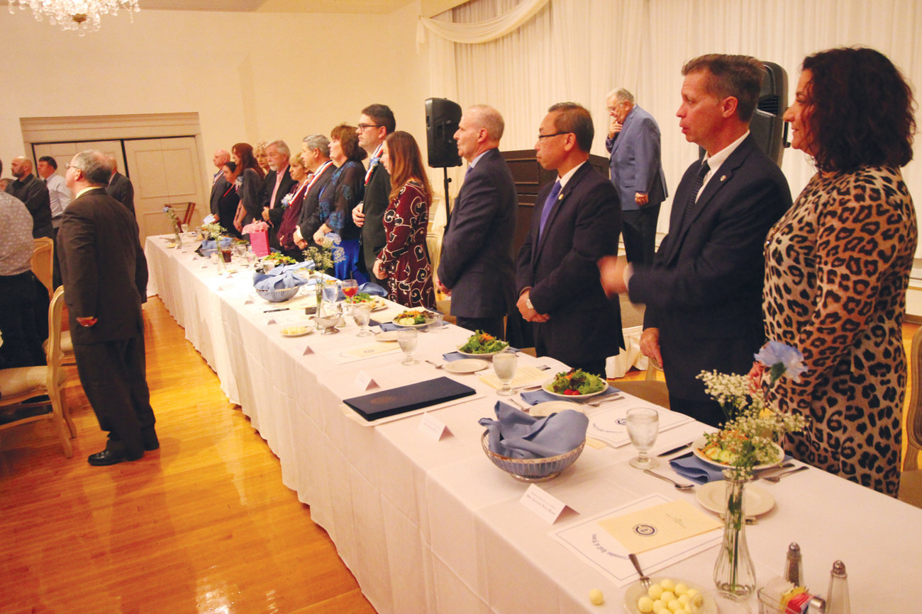CRANSTON PRIDE: Members of the Cranston Hall of Fame’s class of 2019, along with their guests, board members and civic leaders, stand for the Cranston Police Department Honor Guard’s presentation of the colors before Friday’s dinner.